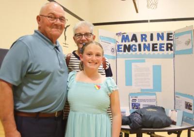 Lily Terra with her grandparents Mark and Joan Terra, in front of her presentation on marine engineering. Terra decided she wants to be a marine engineer because she loves spending time on her grandfather’s boat.