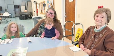 Elizabeth Bryant, 101, sits at a table with one-year-old Everly Kerns and her five-year-old sister Reagan Balch. Also featured is Balch and Kerns’ grandmother, Kathleen Murphy, who is assistant to the senior center director.