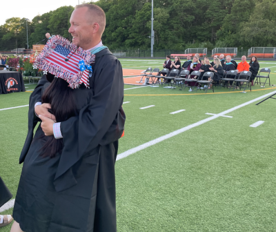 Middleboro High School Assistant Principal Andrew Dizel gives Brooke Main a hug as she prepares to receive her diploma. Photo by Sandy Quadros Bowles
