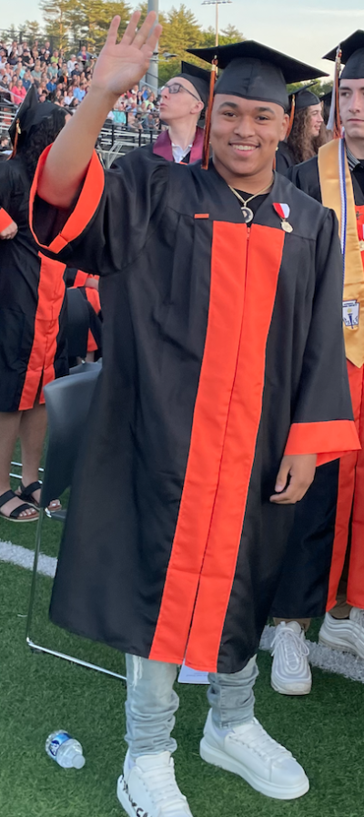 Jayson Pires waves to well-wishers as he prepares to receive his diploma. Photo by Sandy Quadros Bowles