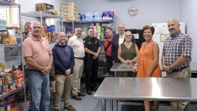 Town officials, and Council on Aging staff pose in the new food pantry at the Lakeville Senior Center.