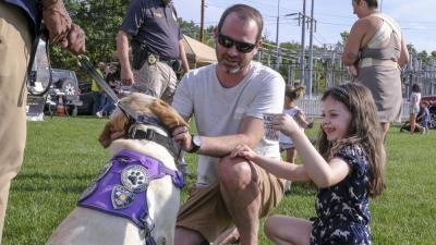 Tyler Phelps and Lea Phelps, 6, pet a comfort service dog, Lexy, at the event. Lea said the comfort dogs were “soft” and “really nice” to pet.