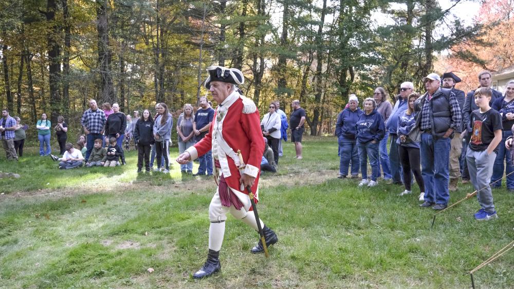 A British soldier reenactor walks in front of the crowd during a drill. NONE