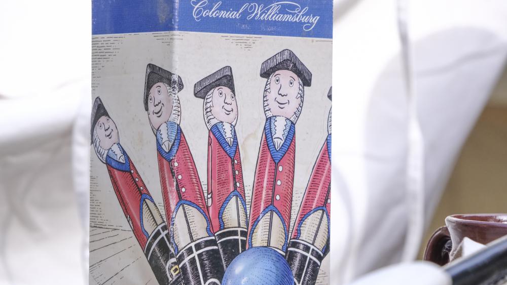 A box-set of miniature wooden bowling pins depicting British soldiers is displayed. NONE