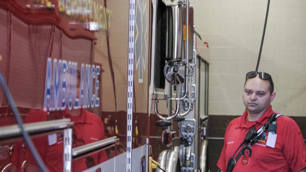 Craig DeCosta stands next to an apparatus. He has "jerry rigged" a handful of radios and scanner throughout the station, since there's not a station-wide intercom system. NONE