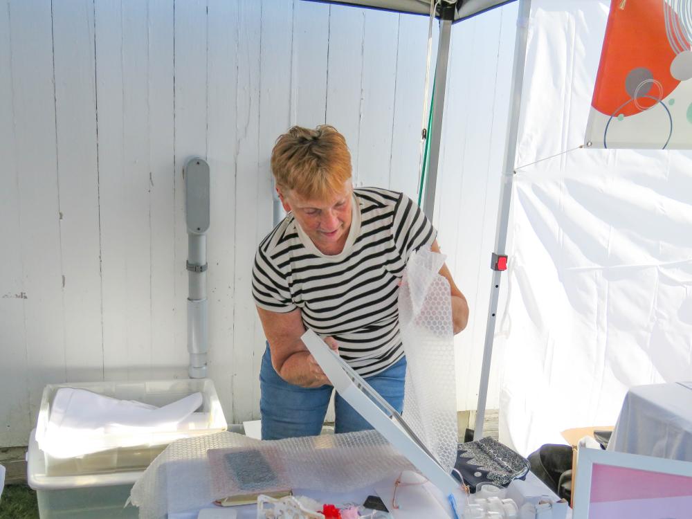 Vendor Sheryl LeBlanc wraps up a piece of art at the festival. Vendor Sheryl LeBlanc wraps up a piece of art at the festival.
