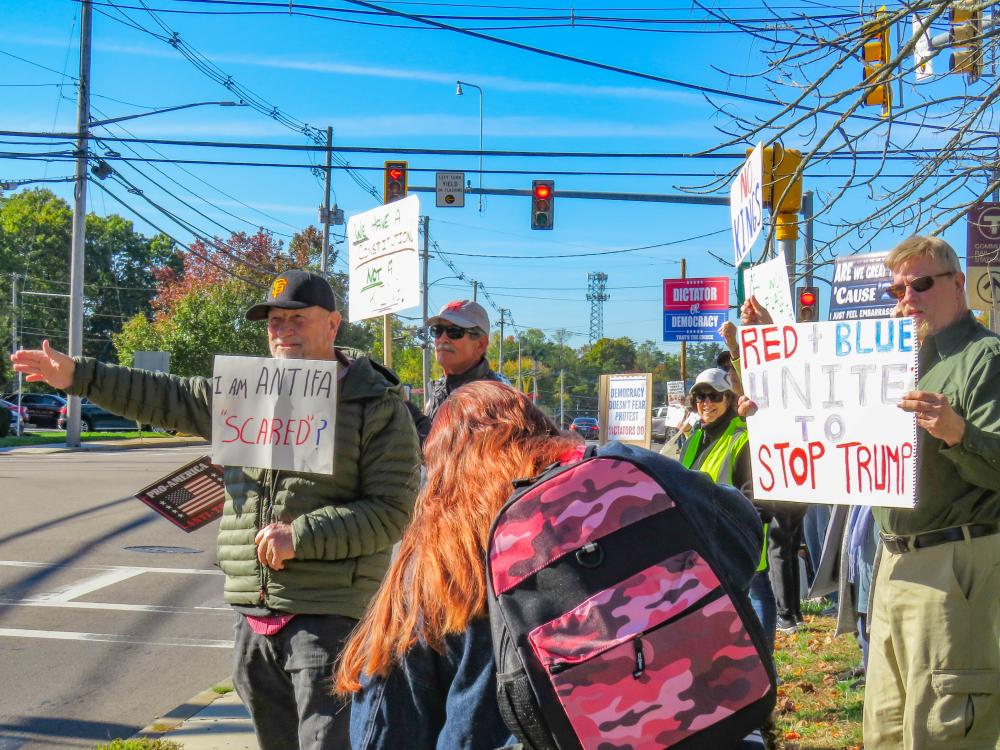 Protesters display their signs to traffic stopped at a red light. Protesters display their signs to traffic stopped at a red light.