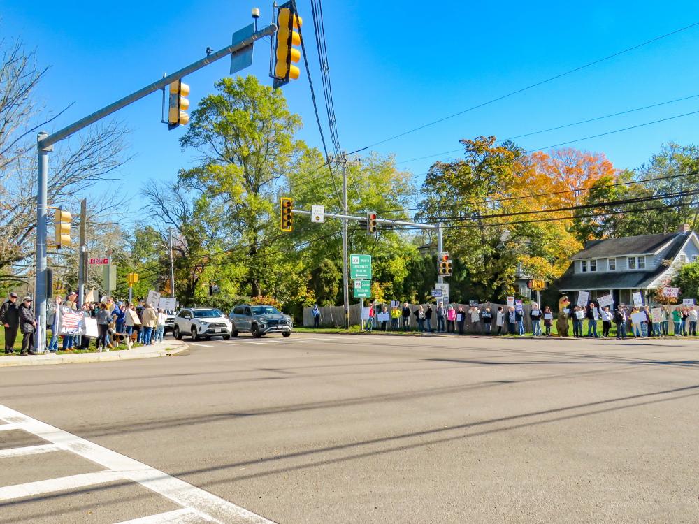 A line of protesters crowd the sidewalks at the junction of Routes 105 and 28. A line of protesters crowd the sidewalks at the junction of Routes 105 and 28.