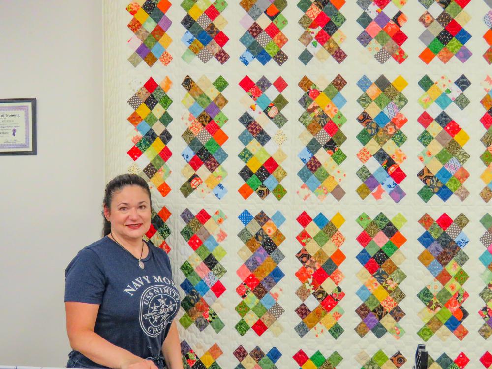 Michelle Medeiros poses with her scrap-fabric quilt inside Homestead Quilting and Fabric on Oct. 12. Photos by Grace Roche Michelle Medeiros poses with her scrap-fabric quilt inside Homestead Quilting and Fabric on Oct. 12.