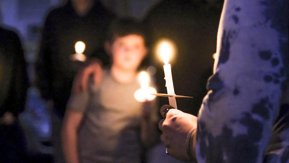 A candle burns during the vigil. NONE