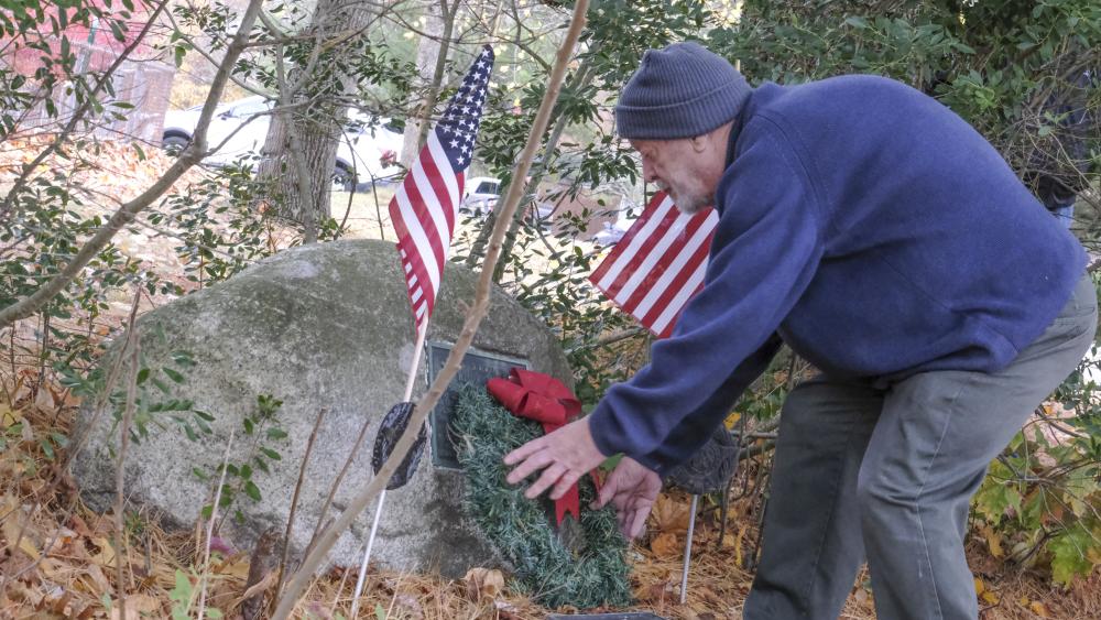Bud Morton, a Lakeville resident and Army veteran, lays a wreath on the Hitchcock Memorial at Assawompset Elementary School. Photo by Sam Tucker