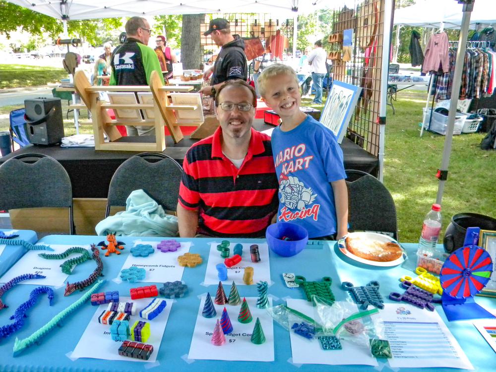 Tristan McPhee, 9, and his father, Gary, at the T's 3D booth. Photo by Christian Uva