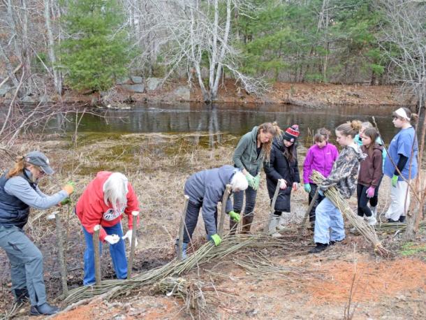 All of the volunteers work together to weave the whips onto the poles. Photos by Kat Sheridan