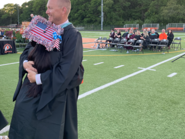 Middleboro High School Assistant Principal Andrew Dizel hugs a student at a previous graduation. File photo