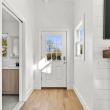 Bright entry hall with new light wood flooring and a view into the updated bathroom at 226 Sanford Road, Westport