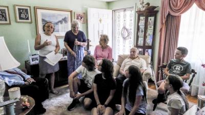 Fernandes’ grandchildren listen to Historical Commission members Delia Murphy, left, and Geri Taylor, second from left as they tell the history of the Boston Post Cane.