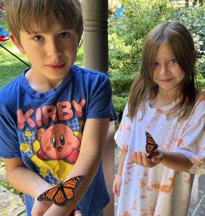 Oscar (left) and Lark Hurley hold the butterflies they raised from caterpillars. 