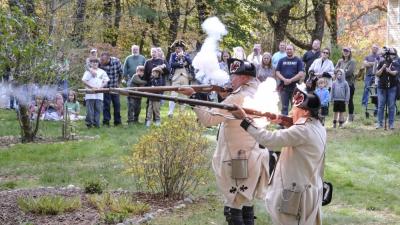 French soldier reenactors fire their muskets in tandem. NONE