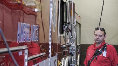 Craig DeCosta stands next to an apparatus. He has "jerry rigged" a handful of radios and scanner throughout the station, since there's not a station-wide intercom system. NONE