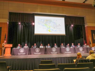 The meeting moderator, Select Board members and Finance Committee members on stage during the meeting. The meeting moderator, Select Board members and Finance Committee members on stage during the meeting.