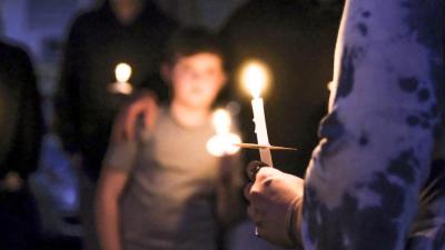 A candle burns during the vigil. NONE