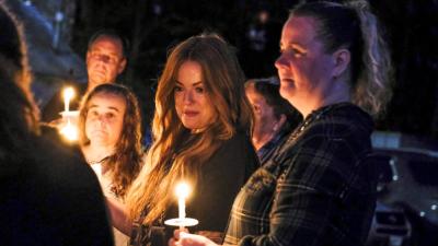 Longtime friends of Nadolny, Kendra Leary, center left, and Shannon Smith, right, look on during the Saturday vigil. NONE