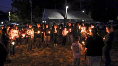 Audience members hold candles as they remembered Nadolny's positive energy and supportive spirit. NONE