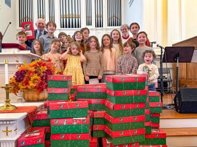 Volunteers stand with the gift boxes they packed at Central Congressional Church. Photo source: Central Congressional Church