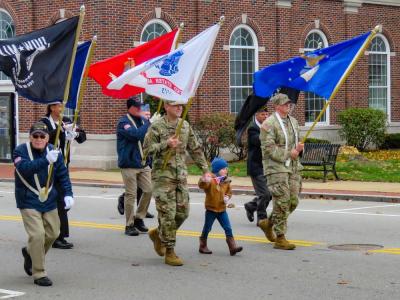 Veterans and active duty service members — one with his son — walk in the Middleboro parade. Photo by Grace Roche