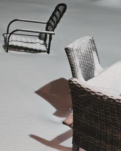 Outdoor chairs are partially buried in snow. 
