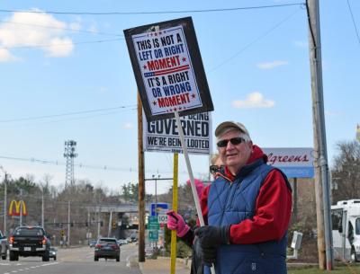 A man proudly holds his sign for all to see.