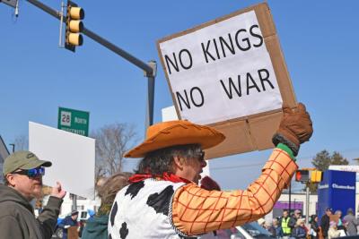 A protester dressed as Woody protests kings and wars.