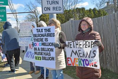 A protester points out how much money those in power have.