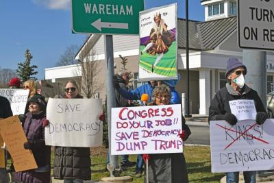 Signs calling for democracy over kings.