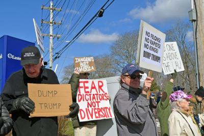 Protesters stand at the corner of the intersection. 