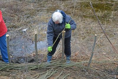 A volunteers weaves the whips.