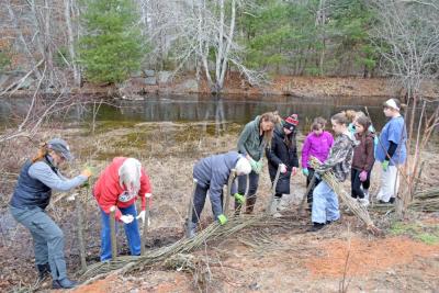 All of the volunteers work together to weave the whips onto the poles. Photos by Kat Sheridan