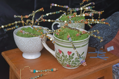 A teacup filled with beaded trees. 