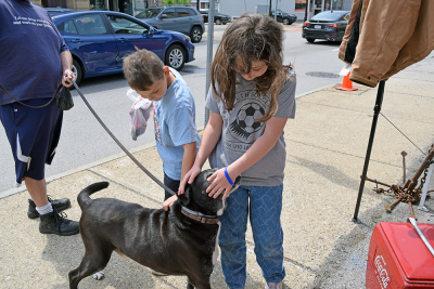Evelyn, 10, and Colton, 7 pet a passing dog.