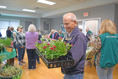 A man very happy with his purchase of plants at the Oak Point plant sale. 