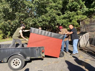 Cash gets help from some friends to replace the donation bin. 