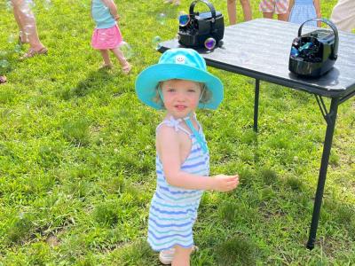 Penny Schuler, 2, poses in front of the bubble blowers. Photo by Christian Uva