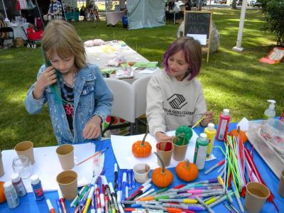 Sisters Lyla, 7, left, and Cheyenne, 9, right, paint pumpkins.