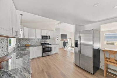 Kitchen with stainless appliances, open to the living area, at 226 Sanford Road in Westport, MA