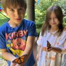 Oscar (left) and Lark Hurley hold the butterflies they raised from caterpillars. 