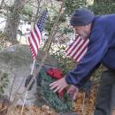 Bud Morton, a Lakeville resident and Army veteran, lays a wreath on the Hitchcock Memorial at Assawompset Elementary School. Photo by Sam Tucker
