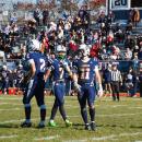 Joseph Procaccini in a muddy jersey walks with his teammates before a play.