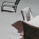 Outdoor chairs are partially buried in snow. 