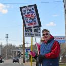 A man proudly holds his sign for all to see.