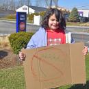 A child holds a sign she drew.